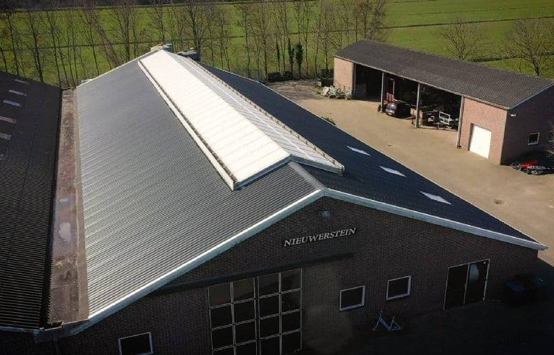 Gerenoveerd staldak met dakpanelen bij melkveestal in Nieuwerbrug
